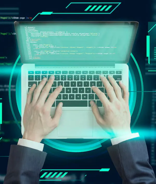 A business professional types code on a laptop, surrounded by a digital interface with green and blue elements, amidst a dark background.